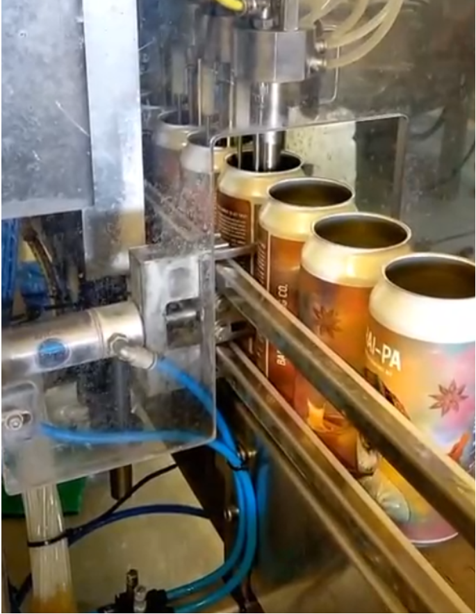 Canning machine filling jars with a visible brand logo on a white background